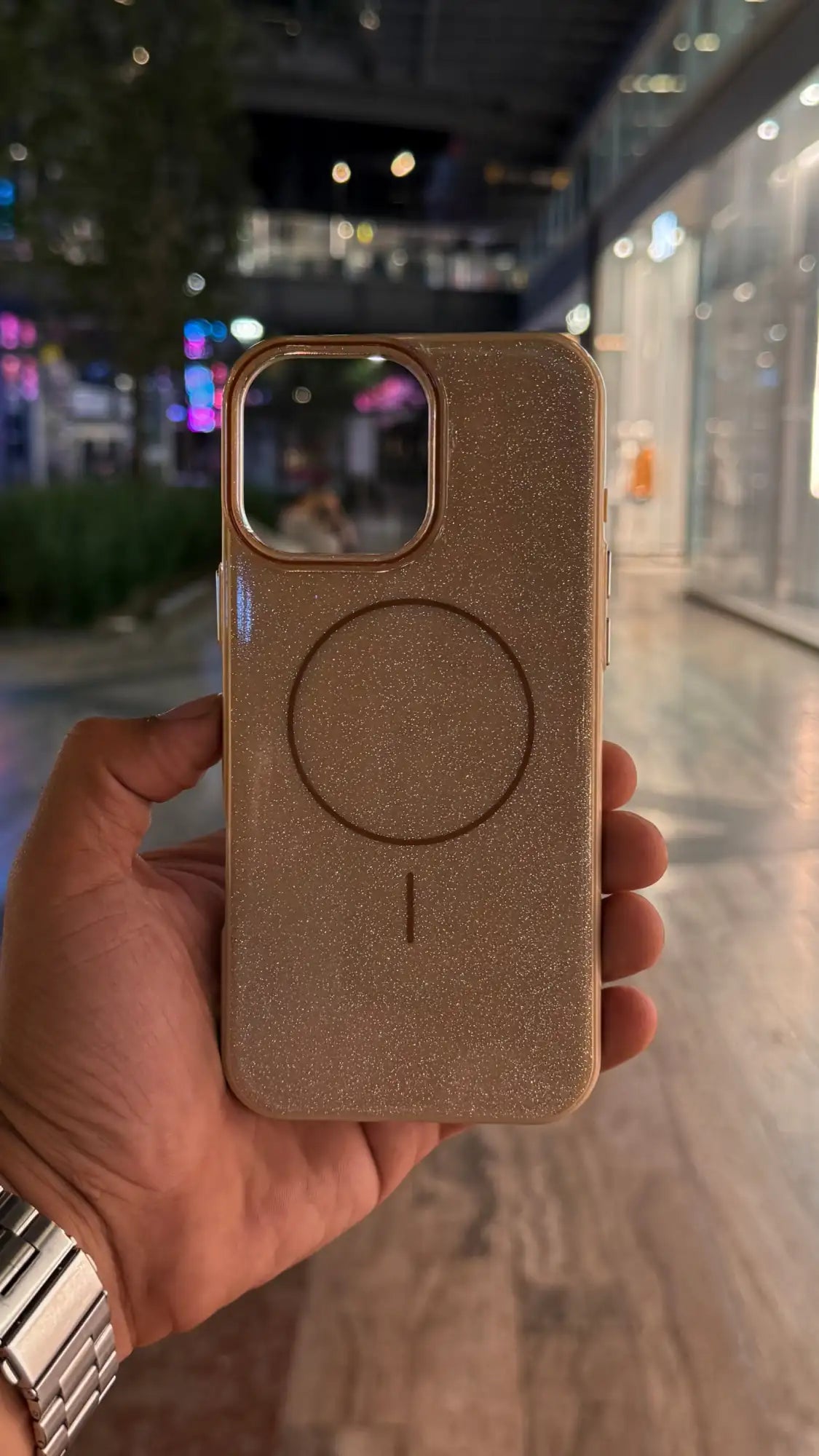 Funda de teléfono con purpurina dorada y diseño de almohadilla de carga magnética circular.