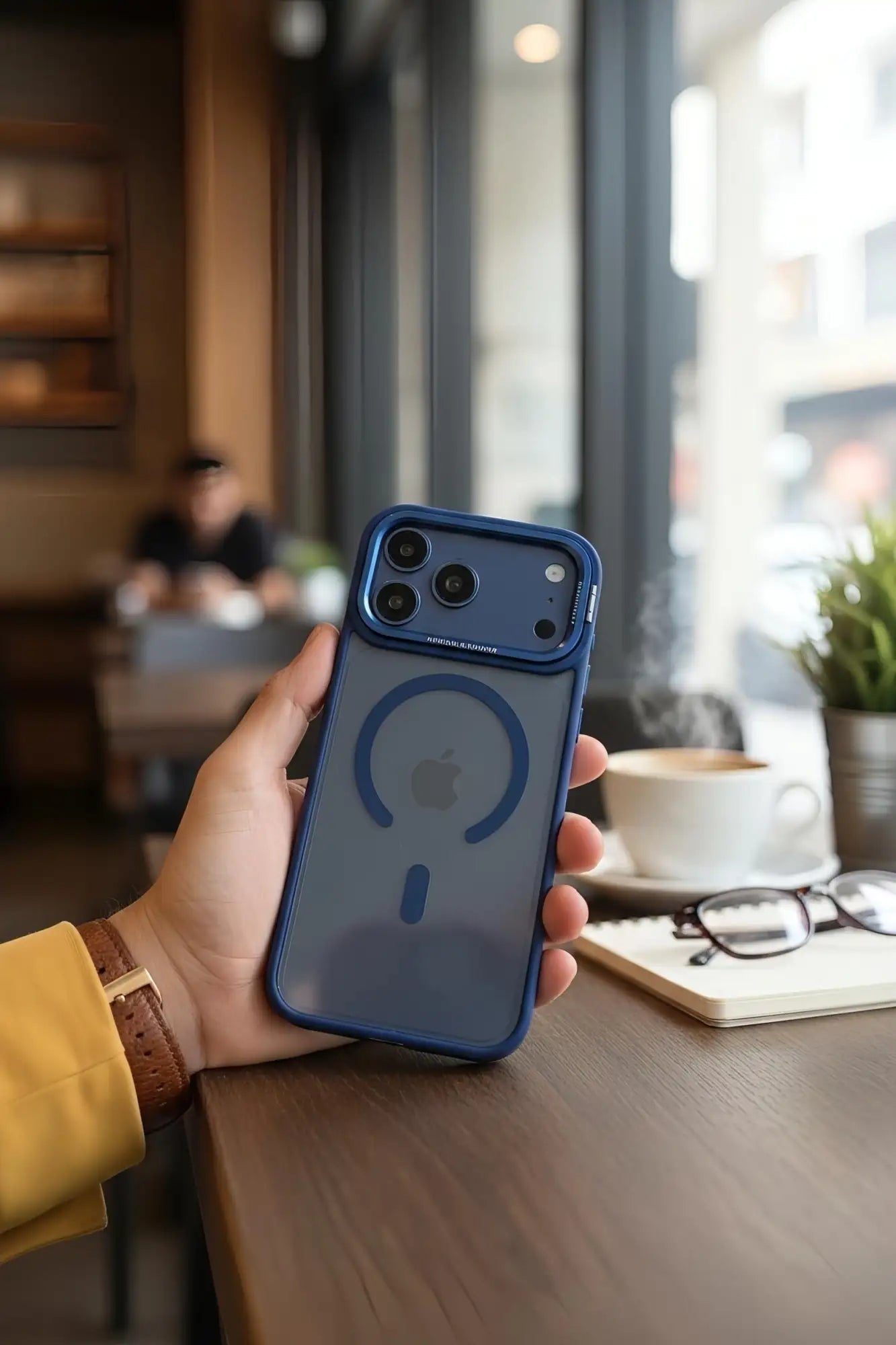 Funda protectora de teléfono azul con panel trasero transparente y diseño de símbolo de carga magnética.