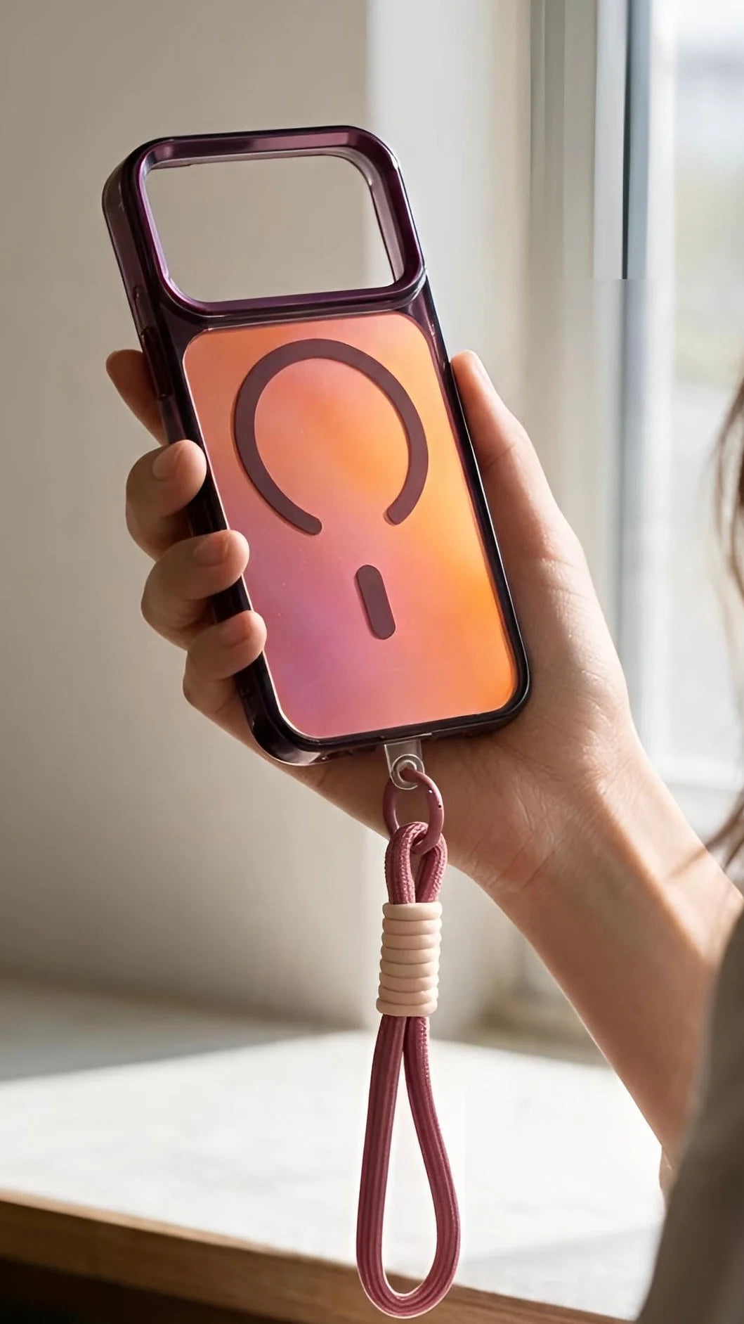 Funda para iphone con acabado tornasol rosa a naranja, botones metálicos y strap tornasol trenzado con puerto magnético